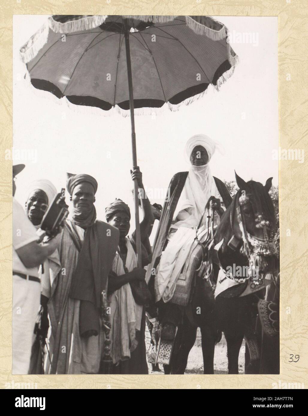 La Nigeria, Emir seduto su un cavallo sotto un ombrello cerimoniale. Geoffrey Morey può essere visto nell'angolo sinistro del tiro con la sua macchina fotografica. La didascalia recita: "L'ETSU (O) Emiro di BIDA', 1960. 2005/010/1/7/39. Foto Stock