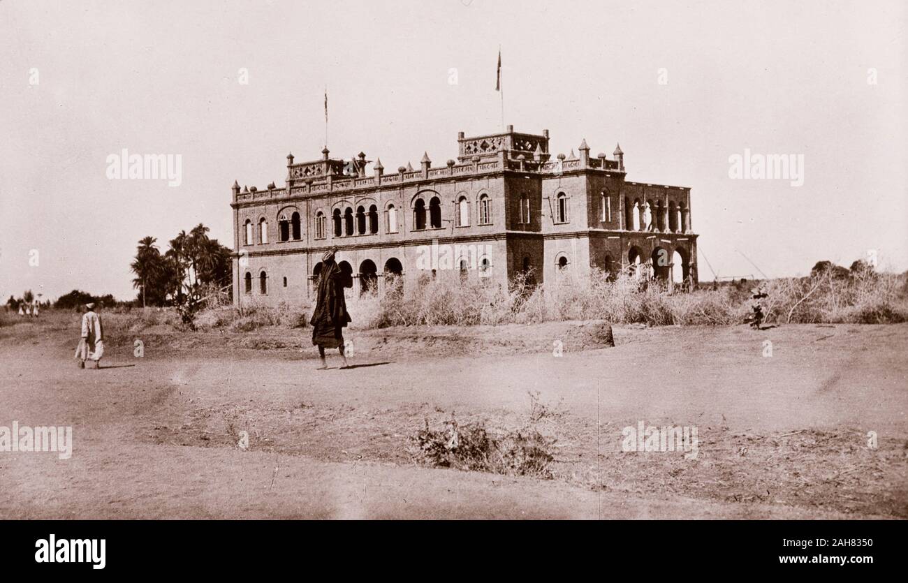 Sudan, stampato didascalia recita: 'governo House, Wad Medani. Pubblicato da G N Morhig, la farmacia inglese, Khartoum. Copyright 181'. Vista della Casa del Governo a Wad Madani, un grande edificio a due piani con arco arrotondato windows, pinnicles lungo il suo parapetto, e due torri quadrate, [c.1906]. 2003/222/1/2/36. Foto Stock