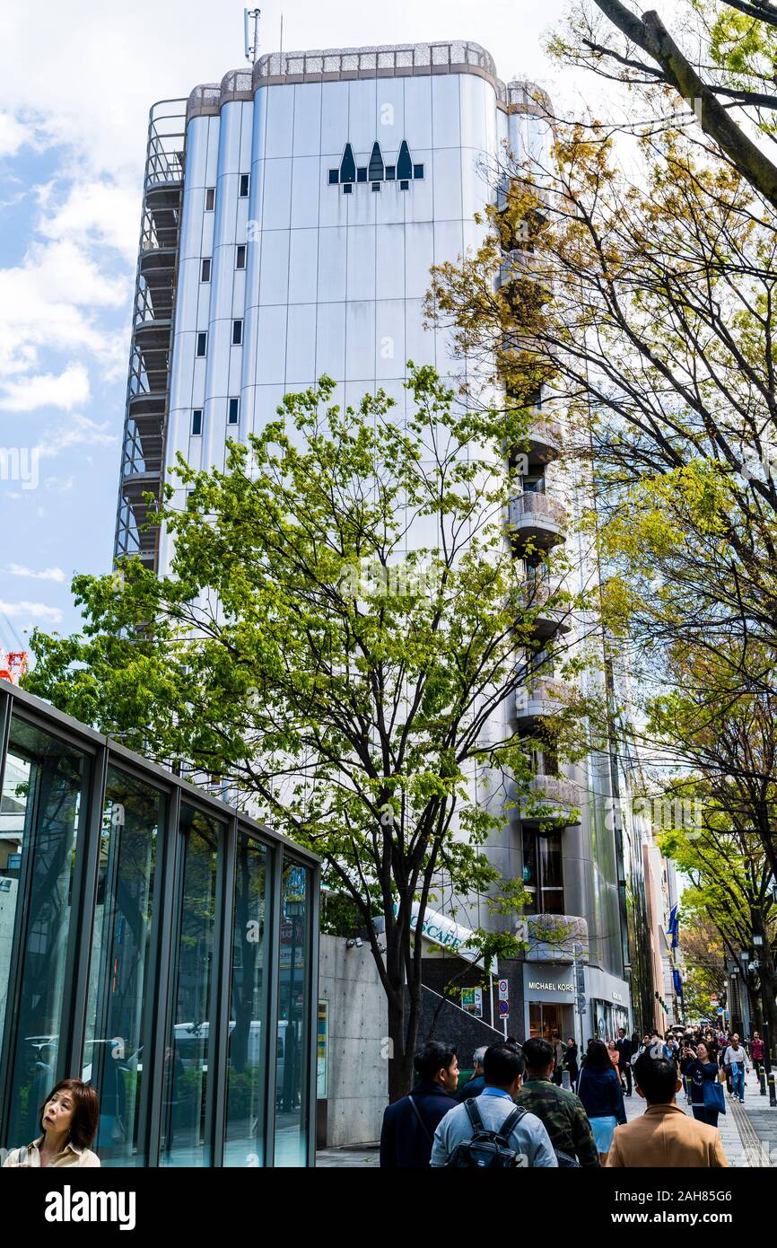 Pannello in titanio facciata su Michael Kors store in Shibuya, Tokyo. Vista lungo l'edificio di dieci piani con pavimentazione occupato con gli acquirenti. La primavera. Foto Stock