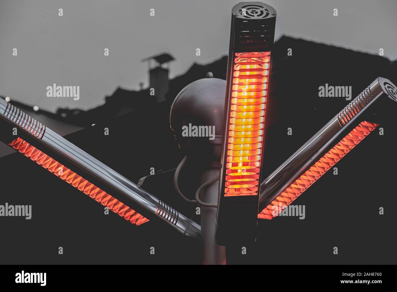 Il calore della lampada a infrarossi patio gas riscaldatori con propano in una calda luce polo sulla strada Foto Stock