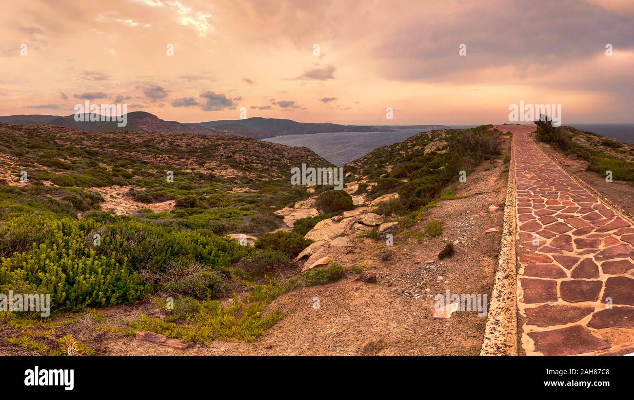 Fantastico tramonto nel deserto del mediterraneo con verdi colline naturali e scogliere a picco sul mare blu con percorso panoramico a Capo Sandalo zona Foto Stock