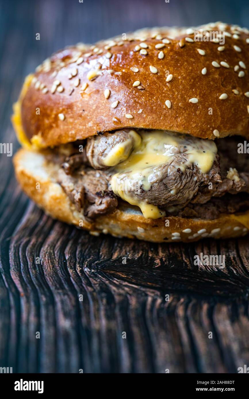 Bistecca hamburger fatto con carne di agnello Lokum e il formaggio Cheddar / Hamburger o Cheeseburger sulla superficie di legno. Fast Food. Foto Stock