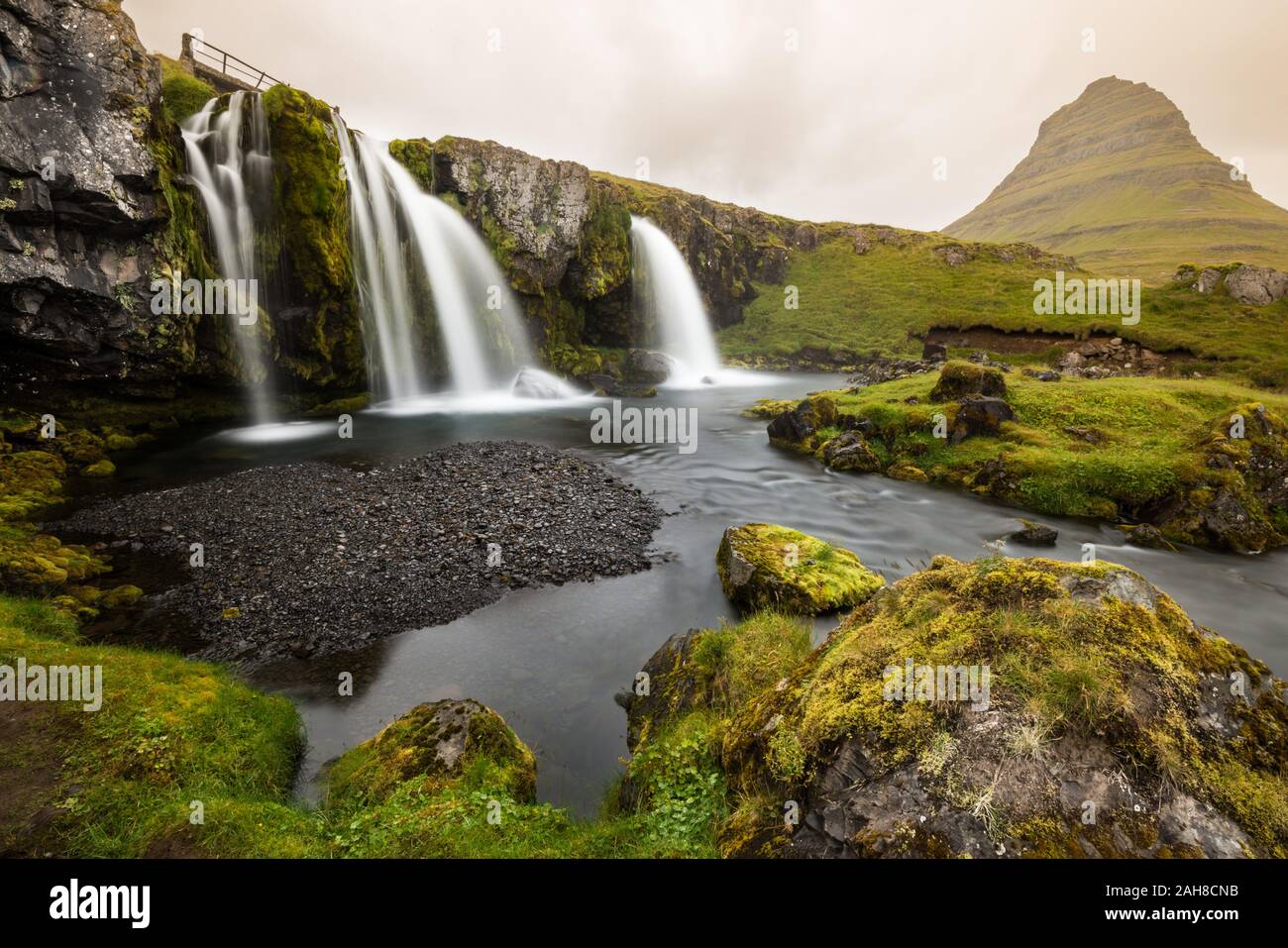 Vista grandangolare dell'iconica cascata islandese di Kirkjufellsfoss alla luce del tardo pomeriggio Foto Stock