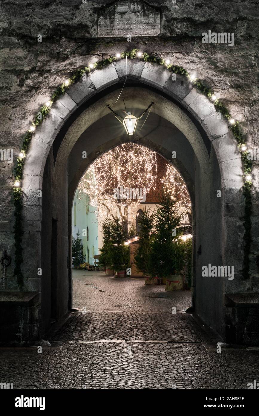 Primo piano di un antico portale medievale, decorato per Natale, in una piccola cittadina del nord Italia Foto Stock