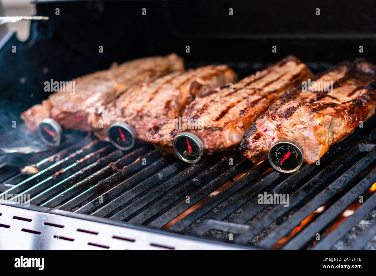 La grigliatura New York strip steak su outdoor grill a gas. Foto Stock