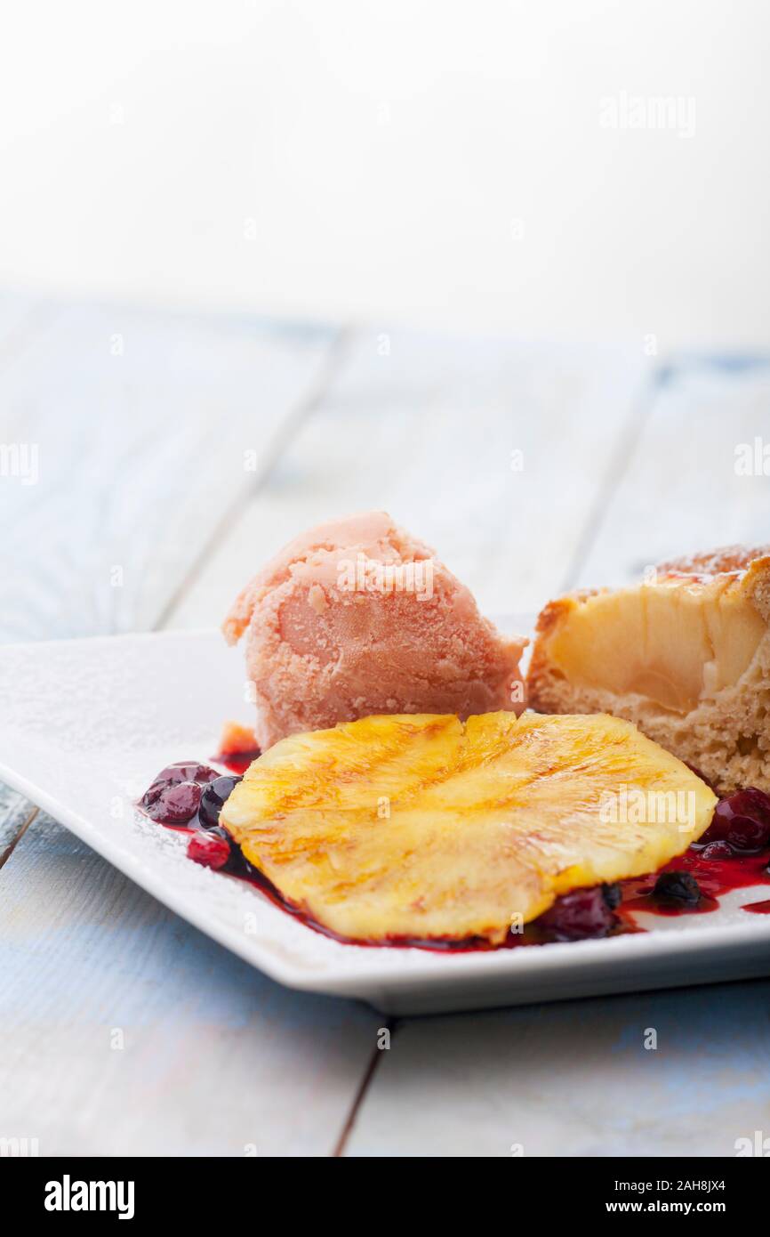 Ananas alla griglia con gelato su una piastra Foto Stock