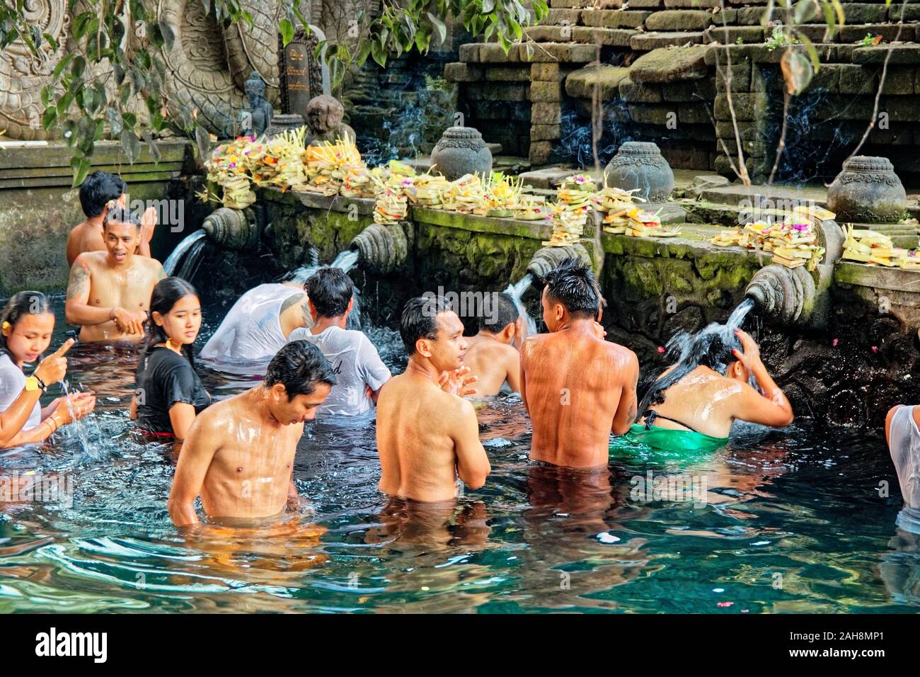 Gruppo di persone in attesa in una que a teste di doccia in primavera sacra acqua in piscina sacra nella Tirta Empul Temple Foto Stock Gruppo di persone in attesa in una que a teste di doccia in primavera sacra acqua in piscina sacra nella Tirta Empul Temple Foto Stock