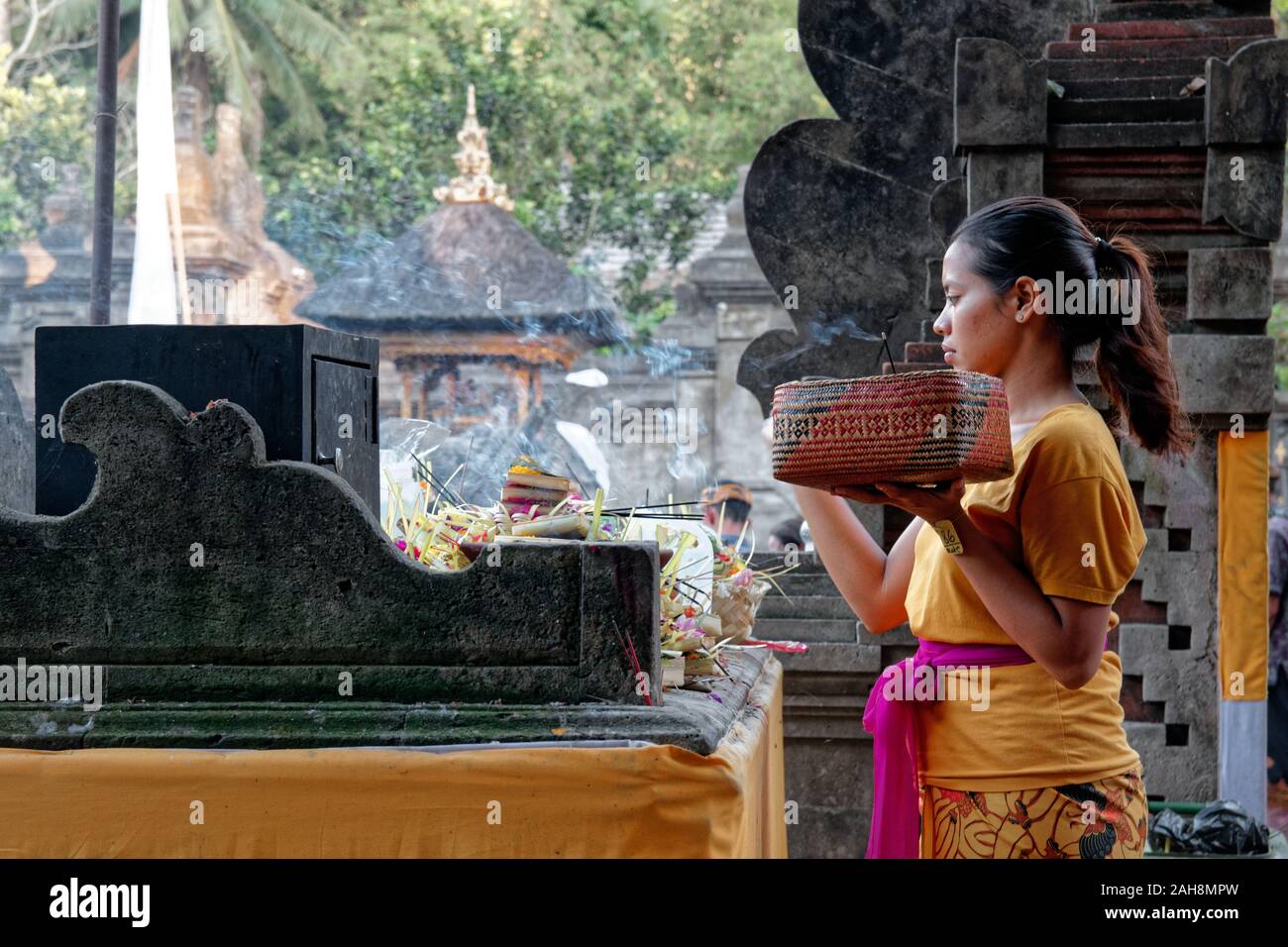 Donna con cesto regalo durante la luna piena cerimonia di Bali in Tirta Empul Temple Foto Stock