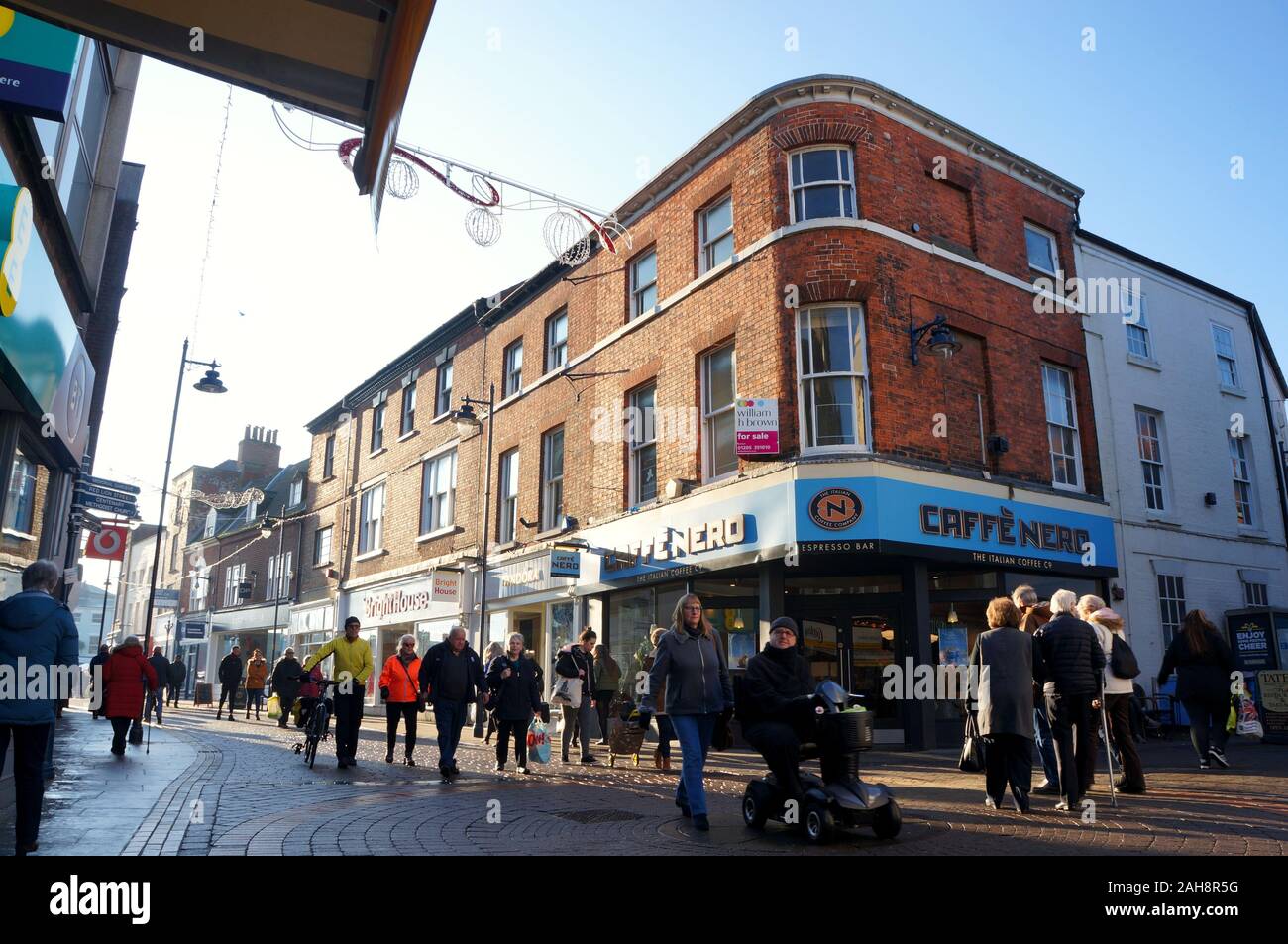 People Christmas shopping nel quartiere della città con Cafe NERO sullo sfondo Foto Stock