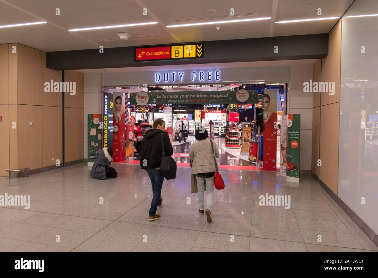 Coppia di viaggiatori che entrano i negozi Duty Free all' Aeroporto di Bruxelles, Belgio Foto Stock