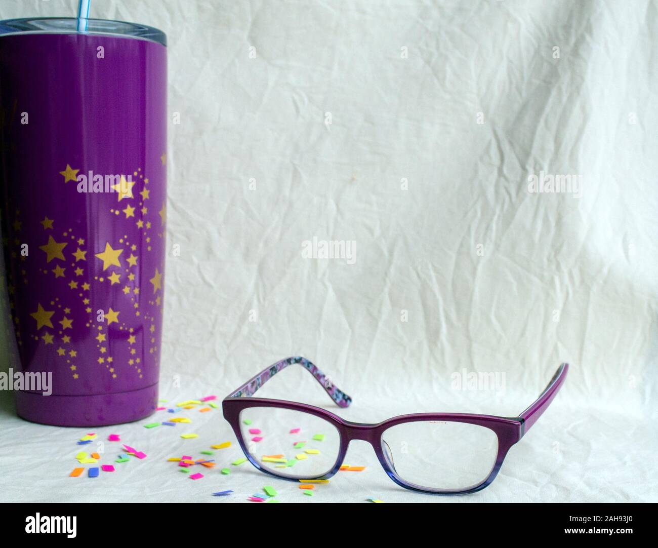 Un drink, bicchieri e coriandoli raffigura un atmosfera di festa con la visione. Bokeh effetto. Foto Stock