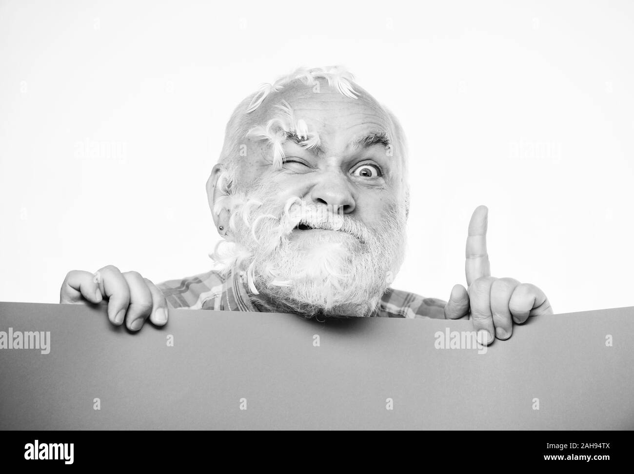 Idea fresca. Senior uomo barbuto luogo annuncio su banner. scioccato uomo maturo con piume capelli grigi. Annuncio. Spazio copia placare le informazioni. Hai bisogno di aiuto. barbiere. Foto Stock