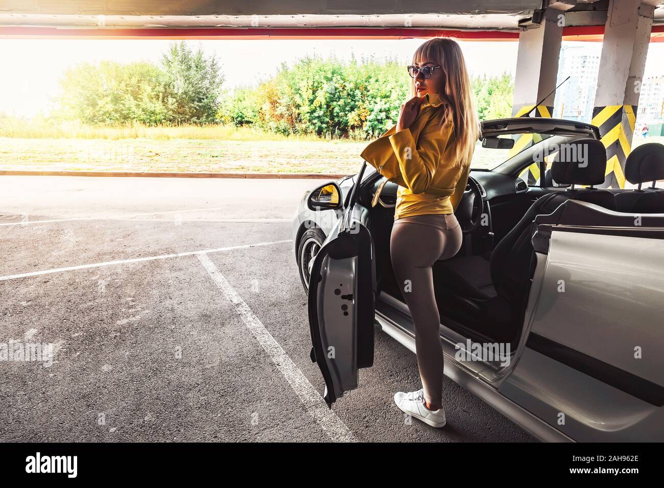 Bella ragazza moderna ottiene fuori per interni auto di classe business, alla moda elegante business donna primavera estate autunno donna. capelli lunghi, car sharing Foto Stock