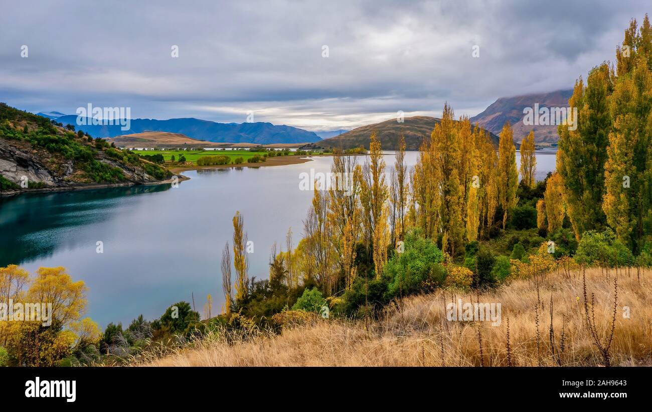 Una vista panoramica di un bellissimo lago di acqua dolce in autunno, circondato da dolci colline e terreni agricoli rurale, sull'Isola del Sud della Nuova Zelanda. Foto Stock
