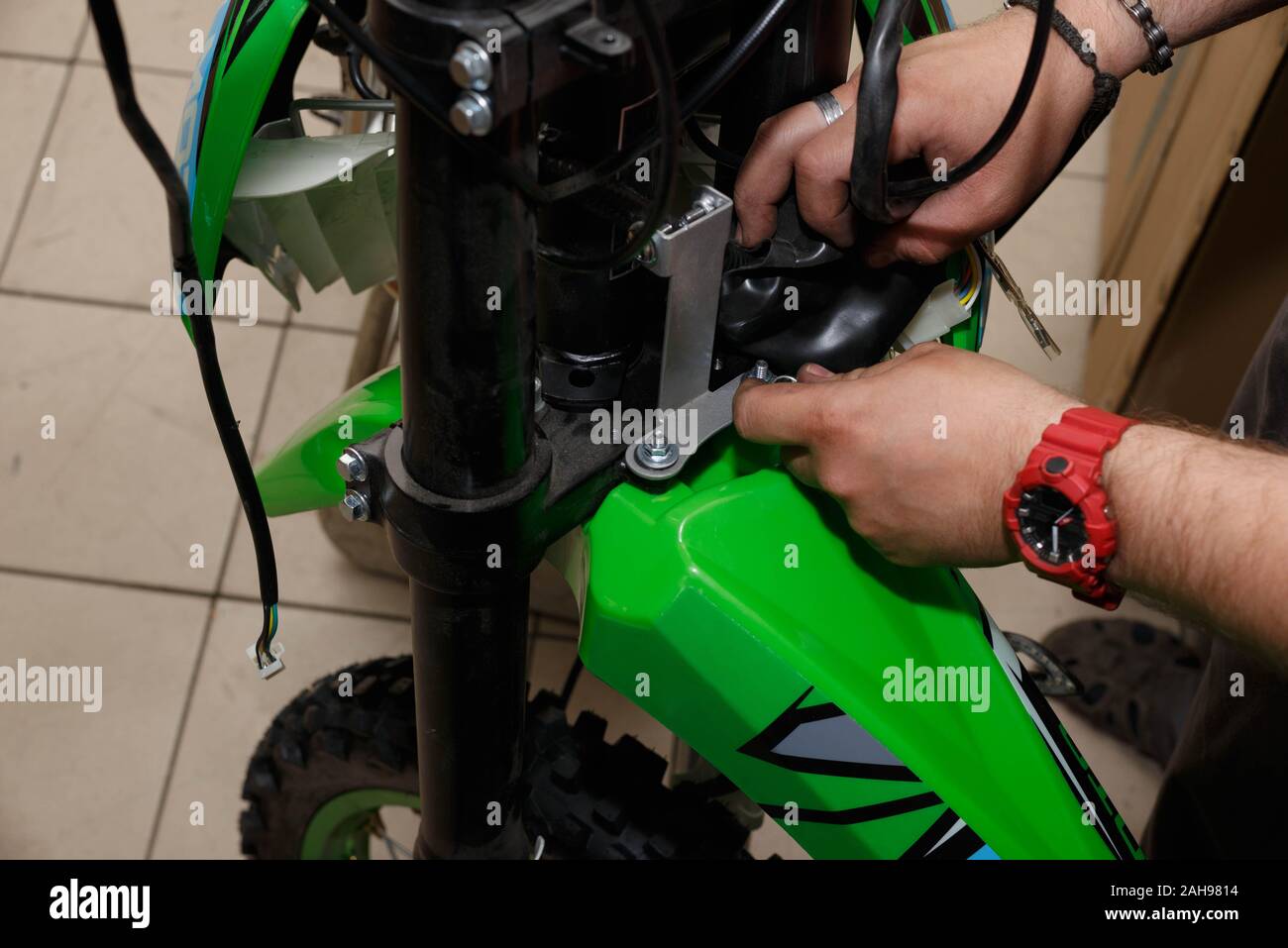 Il processo di collegamento di fili elettrici nel montaggio di una nuova moto durante il funzionamento. Il processo di assemblaggio di una nuova moto. Foto Stock