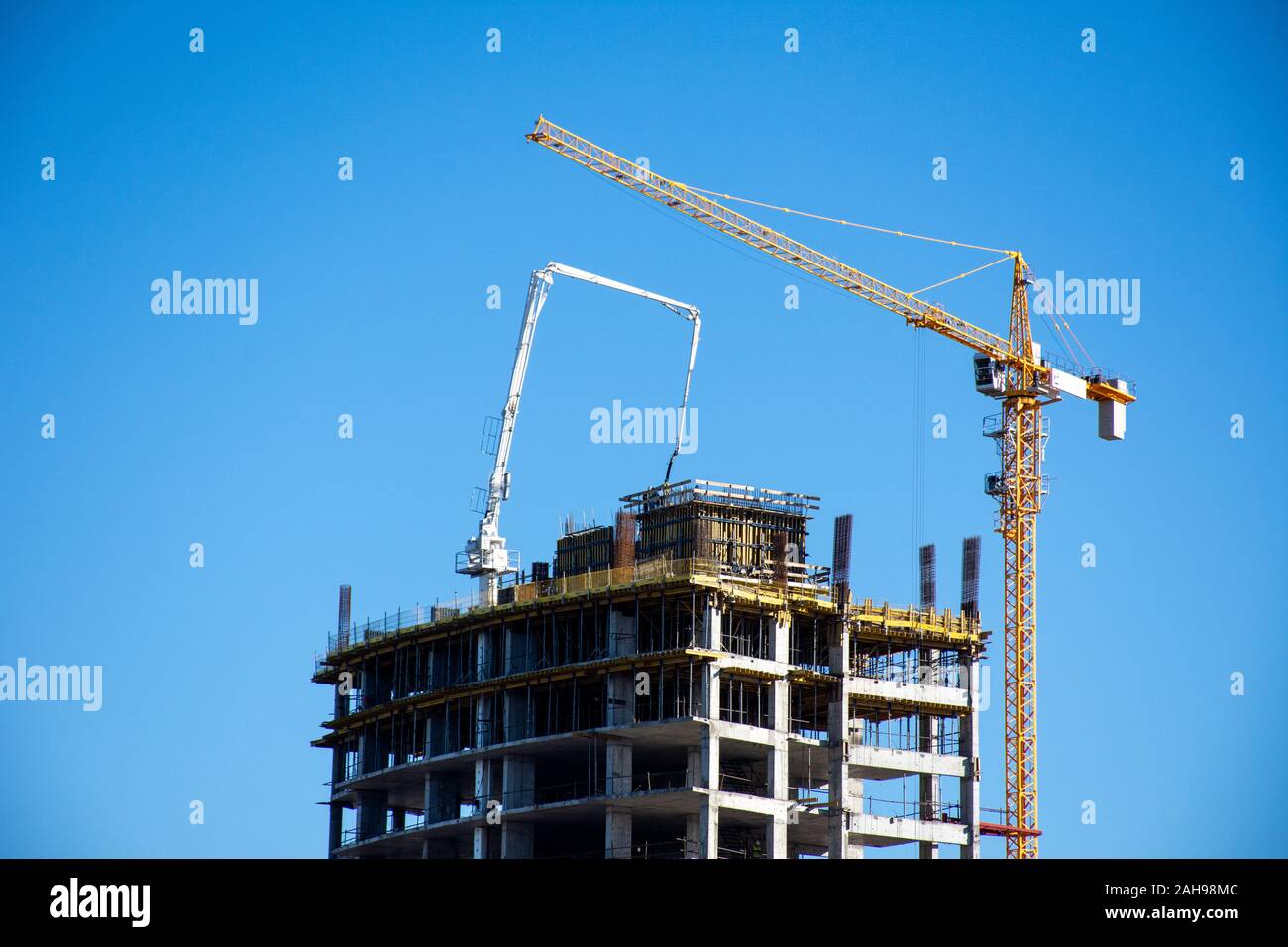 Close up di Ras al Khaimah sviluppo edilizio edificio alto hotel o appartamento complesso edilizio con gru e di calcestruzzo su un bel blu sk Foto Stock