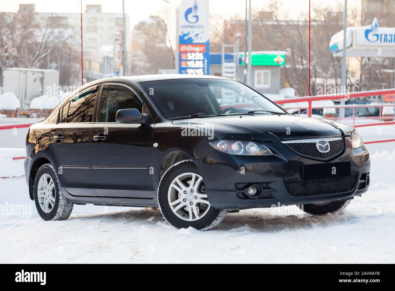 Novosibirsk, Russia - 12.26.2019: Nero Mazda 3 anno 2008 vista frontale con il grigio scuro interno in condizioni eccellenti in uno spazio di parcheggio tra le altre auto Foto Stock