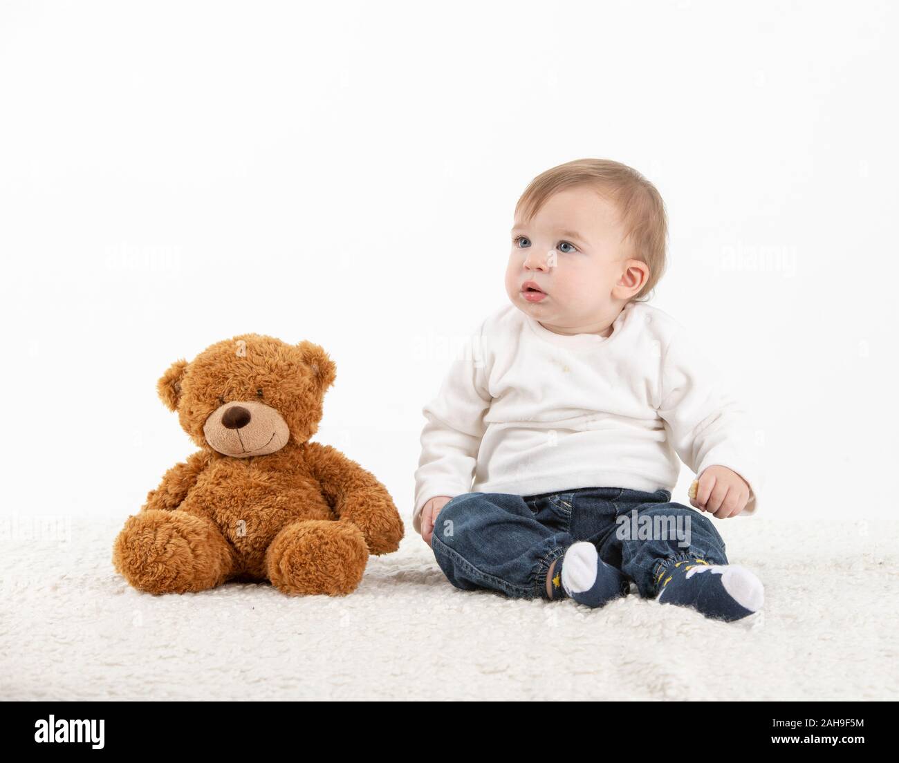 Studio foto con sfondo bianco di un bambino con un orsacchiotto di peluche  Foto stock - Alamy