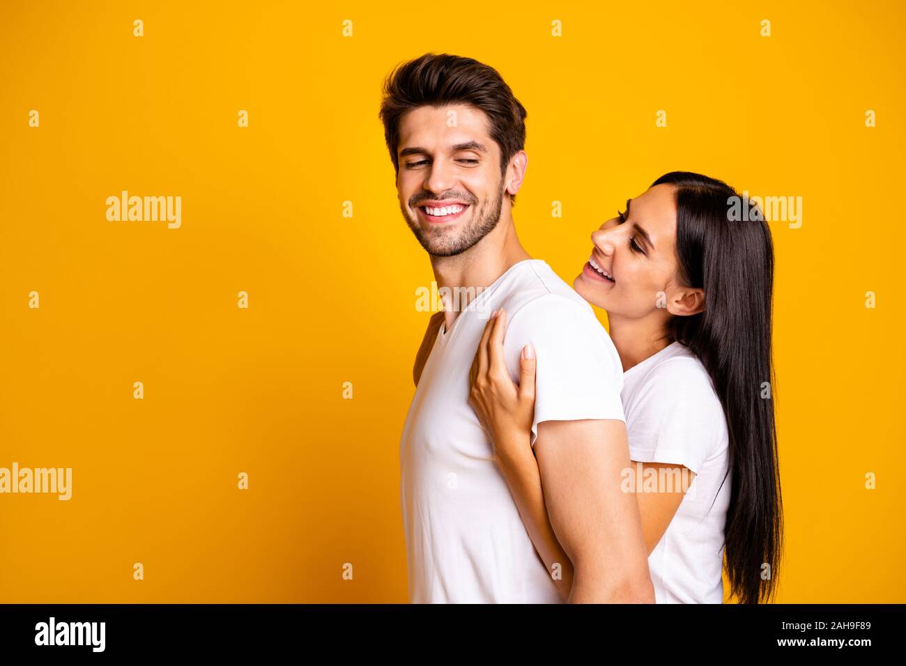 Foto del profilo di coppia incredibile in love lady holding piggyback forte, retro del ragazzo casual wear white t-shirts isolato giallo colore di sfondo Foto Stock