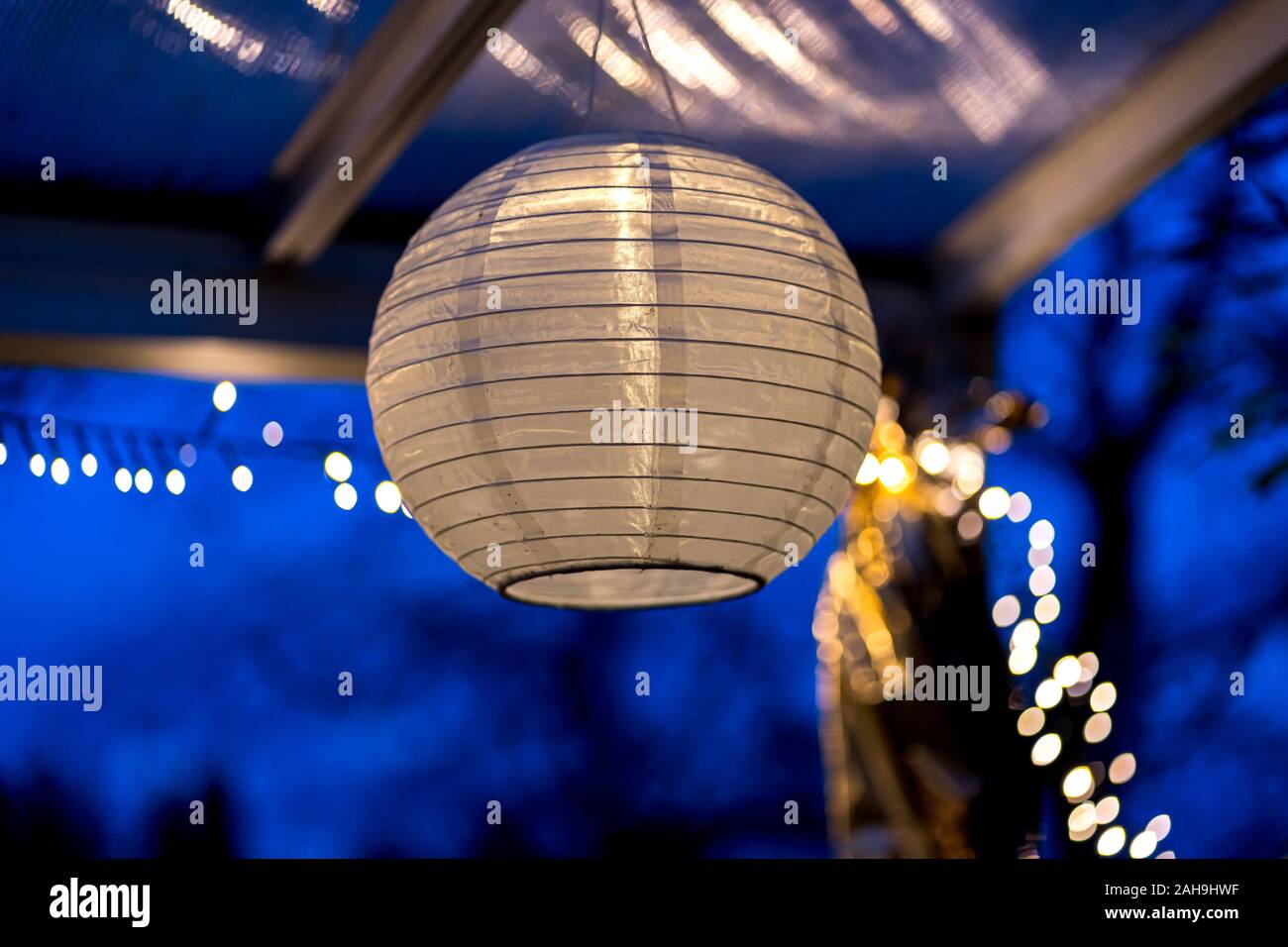 Lanterna cinese si blocca su un tetto di notte al di fuori della casa Foto Stock