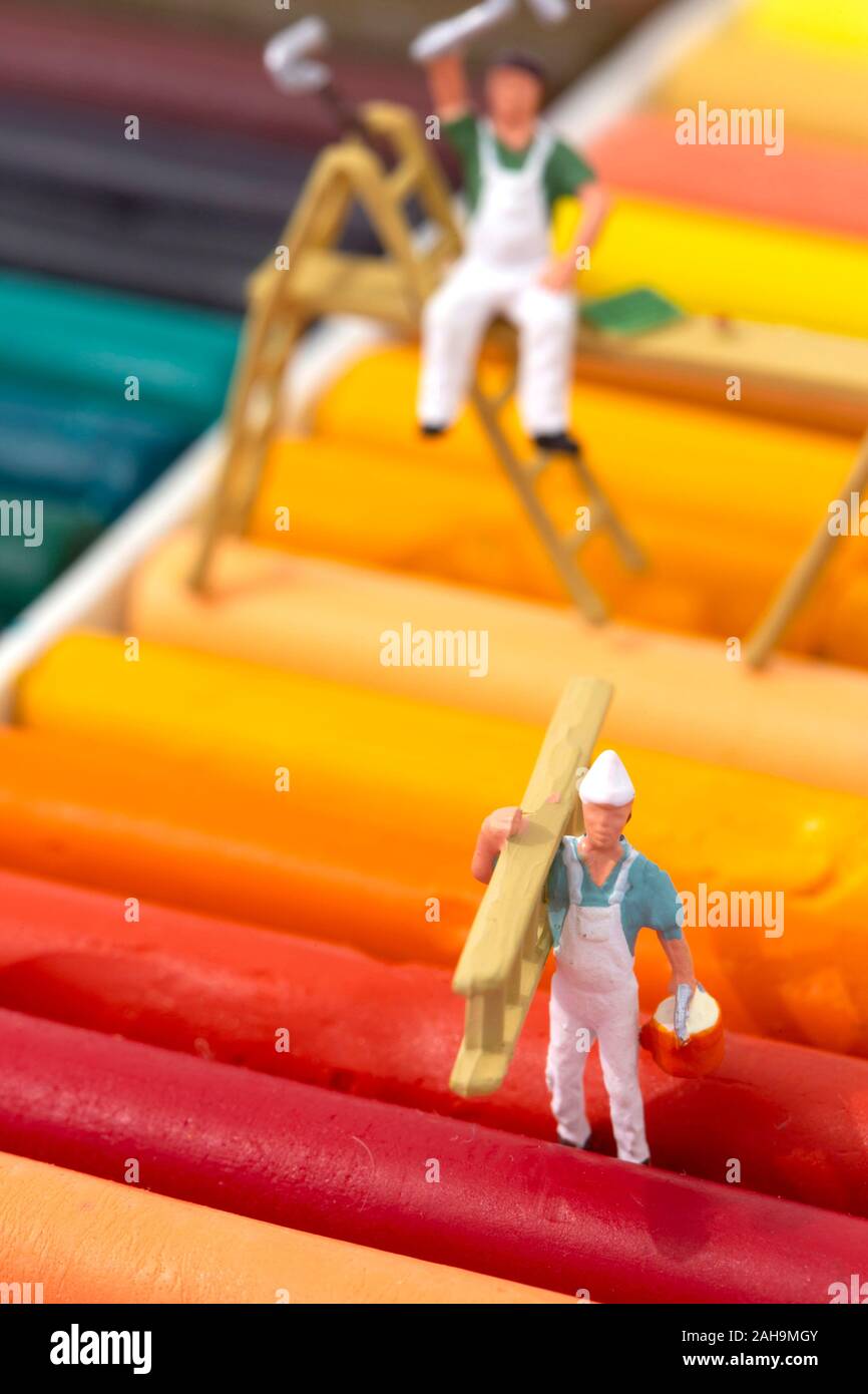 Miniatura modello in scala di pittori e decoratori con scale su un set di pastello olio pastelli. Concetto di decorazione Foto Stock