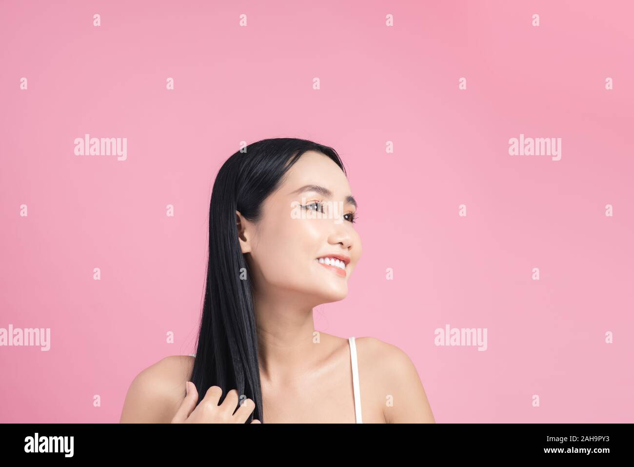 Attraente donna asiatica prendendo cura dei capelli Foto Stock