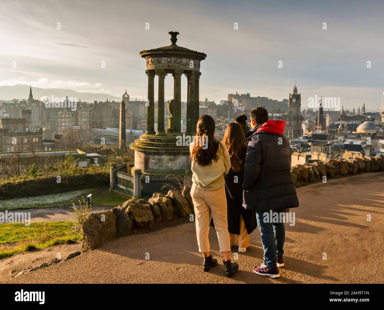 Edimburgo Scozia Inverno tempo città vista da Calton Hill e DUGALD STEWART MEMORIAL CON UN GRUPPO DI QUATTRO TURISTI Foto Stock