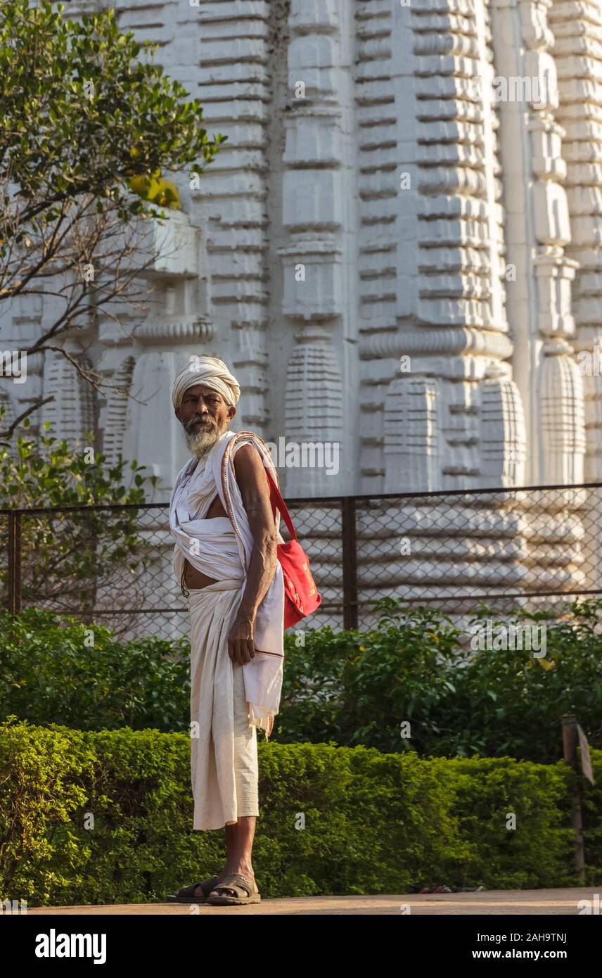 Bhubaneshwar, Orissa, India - Febbraio 2018: Un ritratto candid di un pellegrino anziano con lo sfondo di un antico tempio. Foto Stock