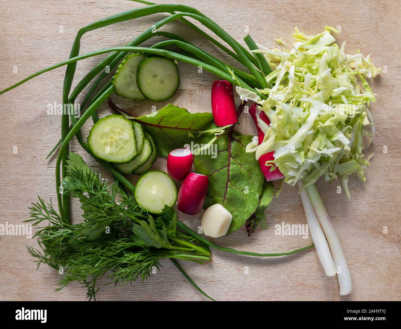 Vista superiore su di un bordo di taglio con ingredienti per vegano insalata di primavera Foto Stock