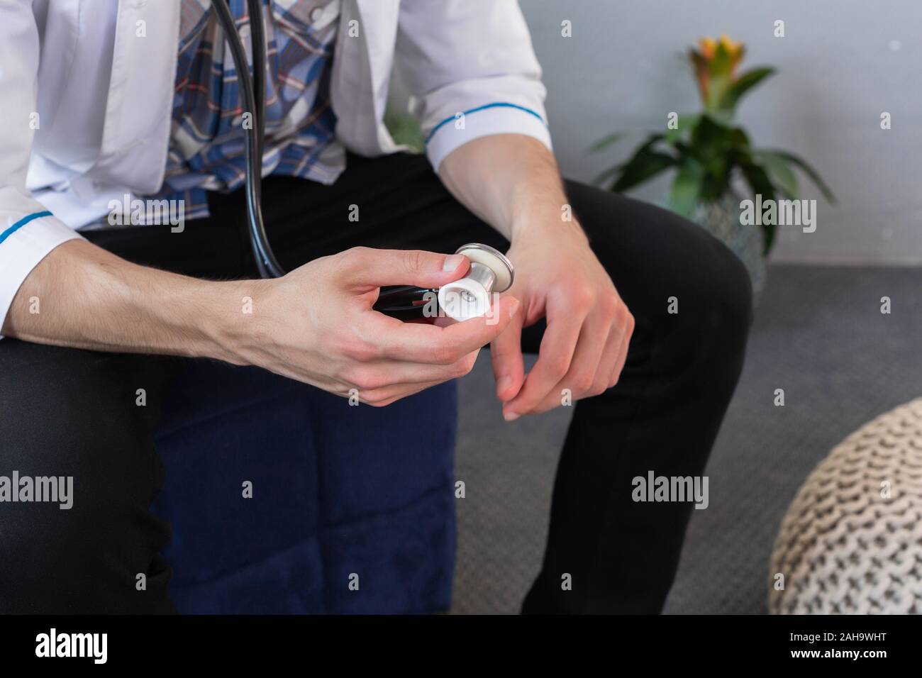 Medico tenendo uno stetoscopio in sua mano indossando camice, pronti ad esaminare un paziente. Close up Foto Stock