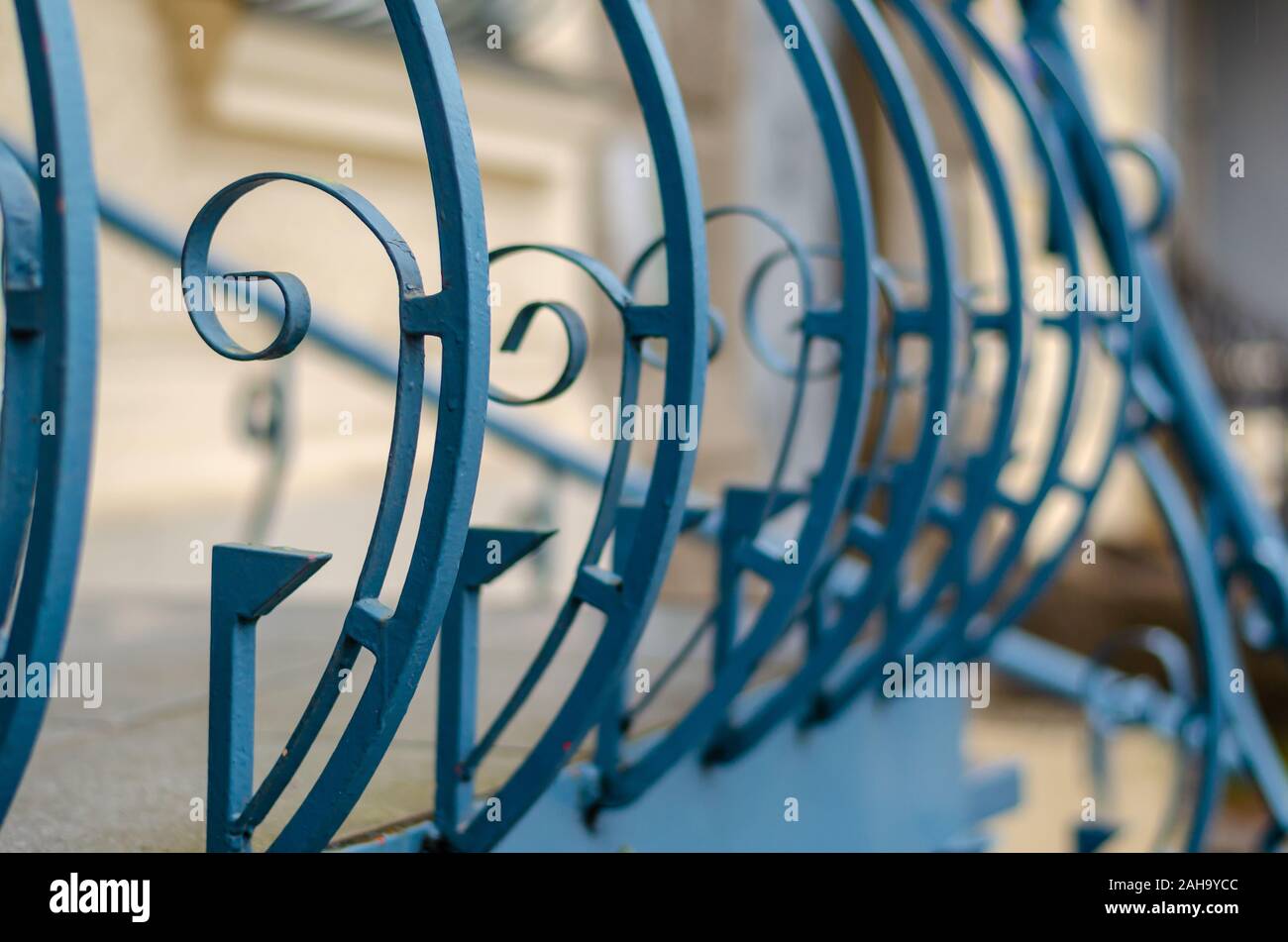 Elegante ringhiera metallica delle scale esterne. Close-up di blu e di recinzione di l'entrata principale dell'edificio. Il livello degli occhi di ripresa. Messa a fuoco selettiva. Foto Stock