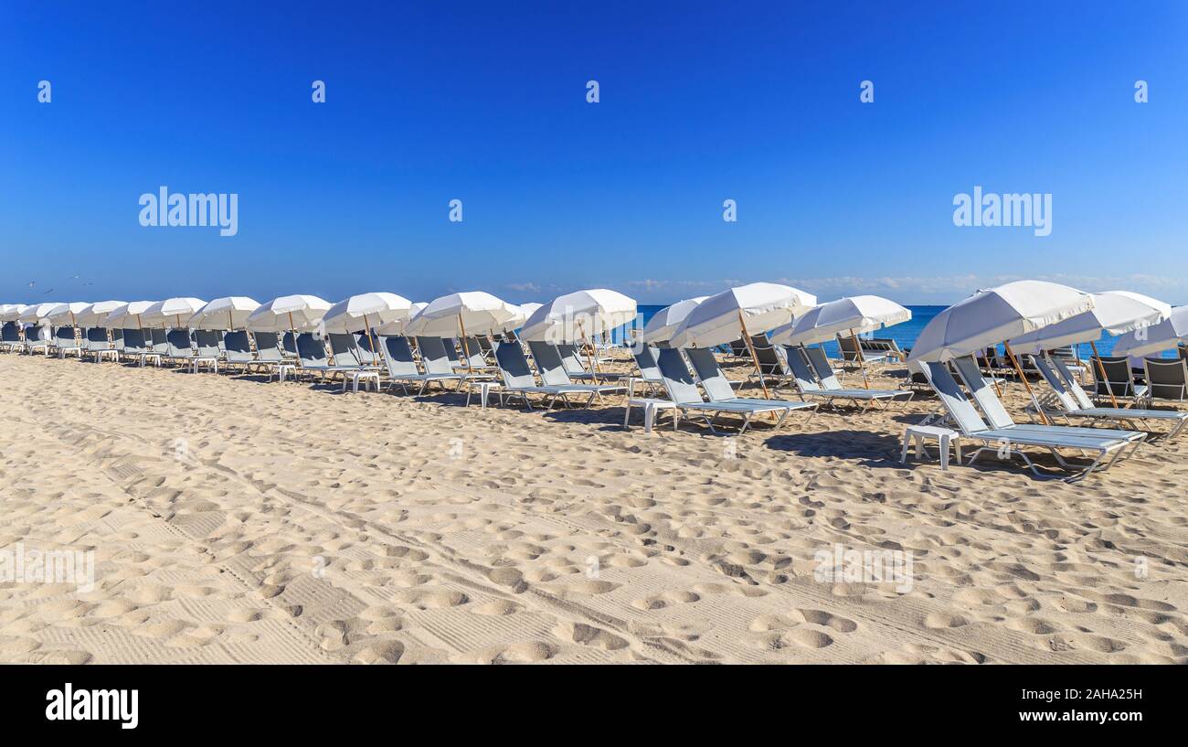 Una fila di ombrelloni sulla spiaggia Foto Stock