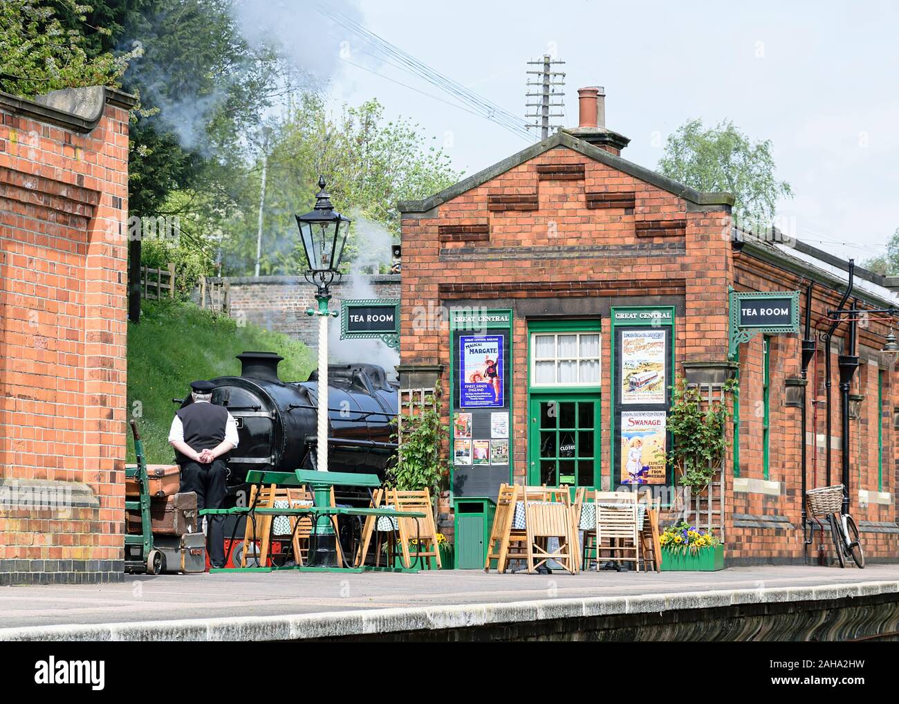 ROTHLEY grande centrale di treni a vapore, Regno Unito - 2015 : Motore di Vapore attende a plaform, mentre la sation matre pattuglie di fronte la stazione sala da tè Foto Stock