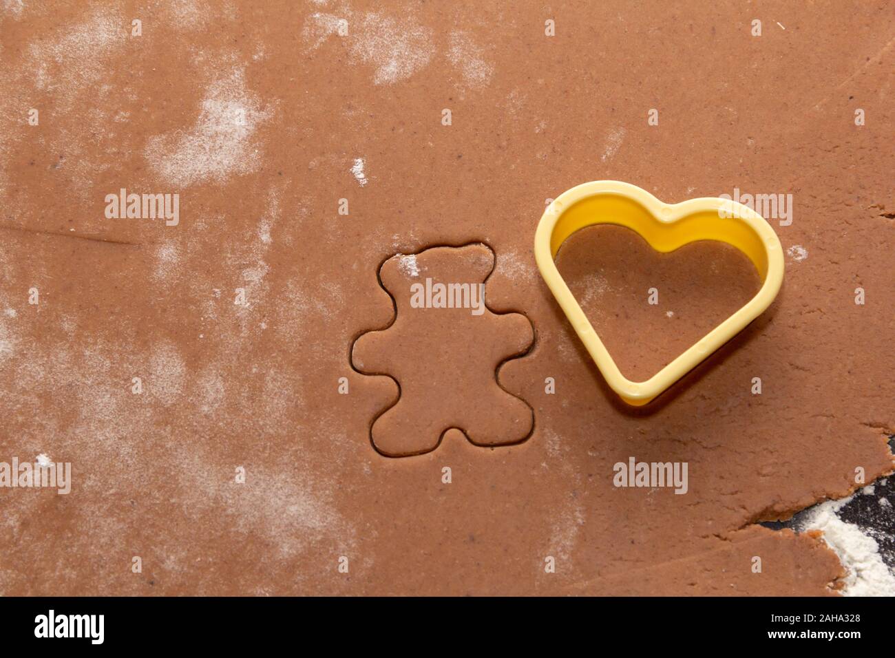 Il taglio di figure da la pasta utilizzando speciali stencil per realizzare lo zenzero biscotti di Natale. Casa, famiglia preparare per il concetto di vacanze Foto Stock