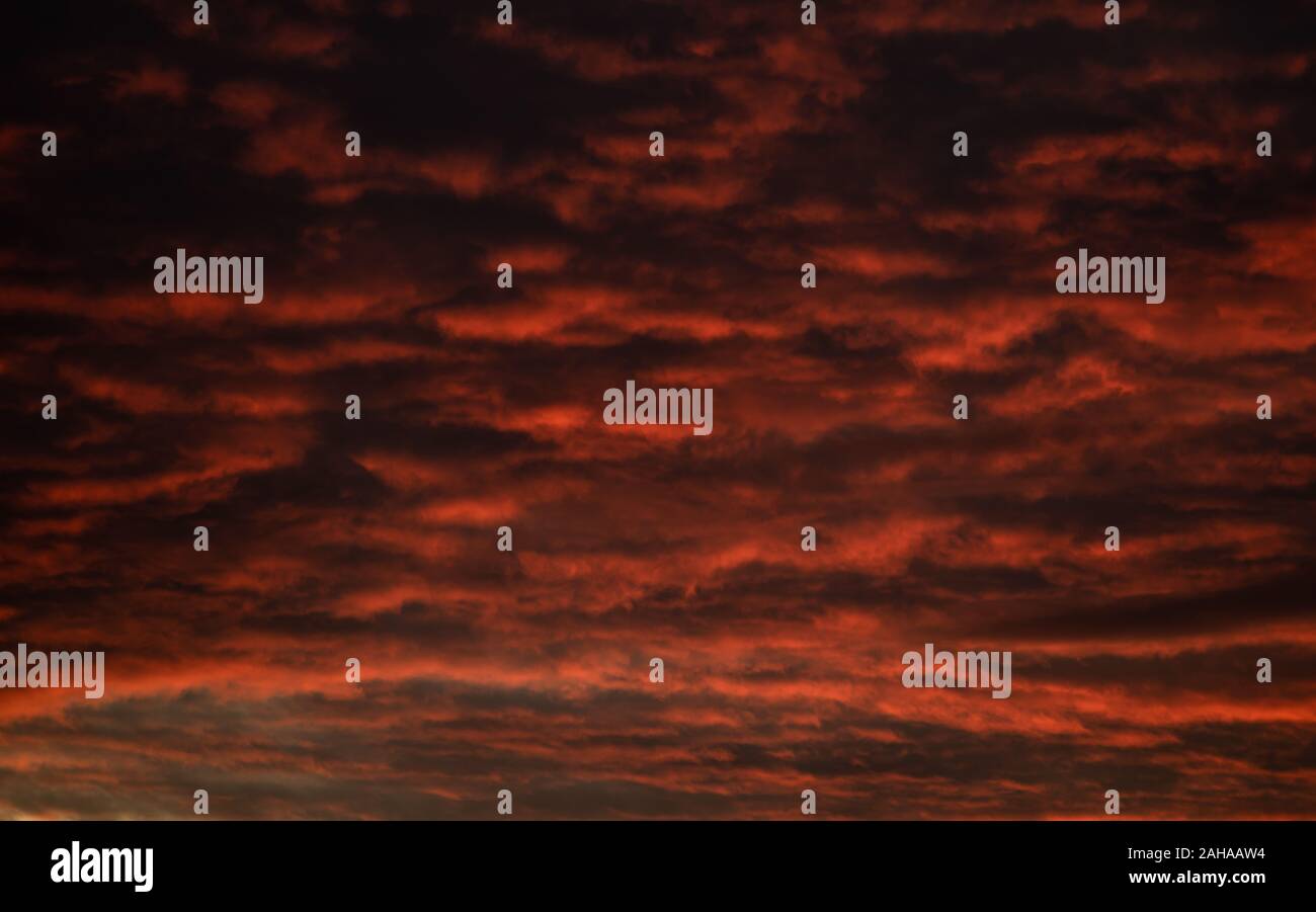 Una tempesta di imminente al tramonto di riflessi verso il basso con il rosso mette in luce e ombre scure. Foto Stock