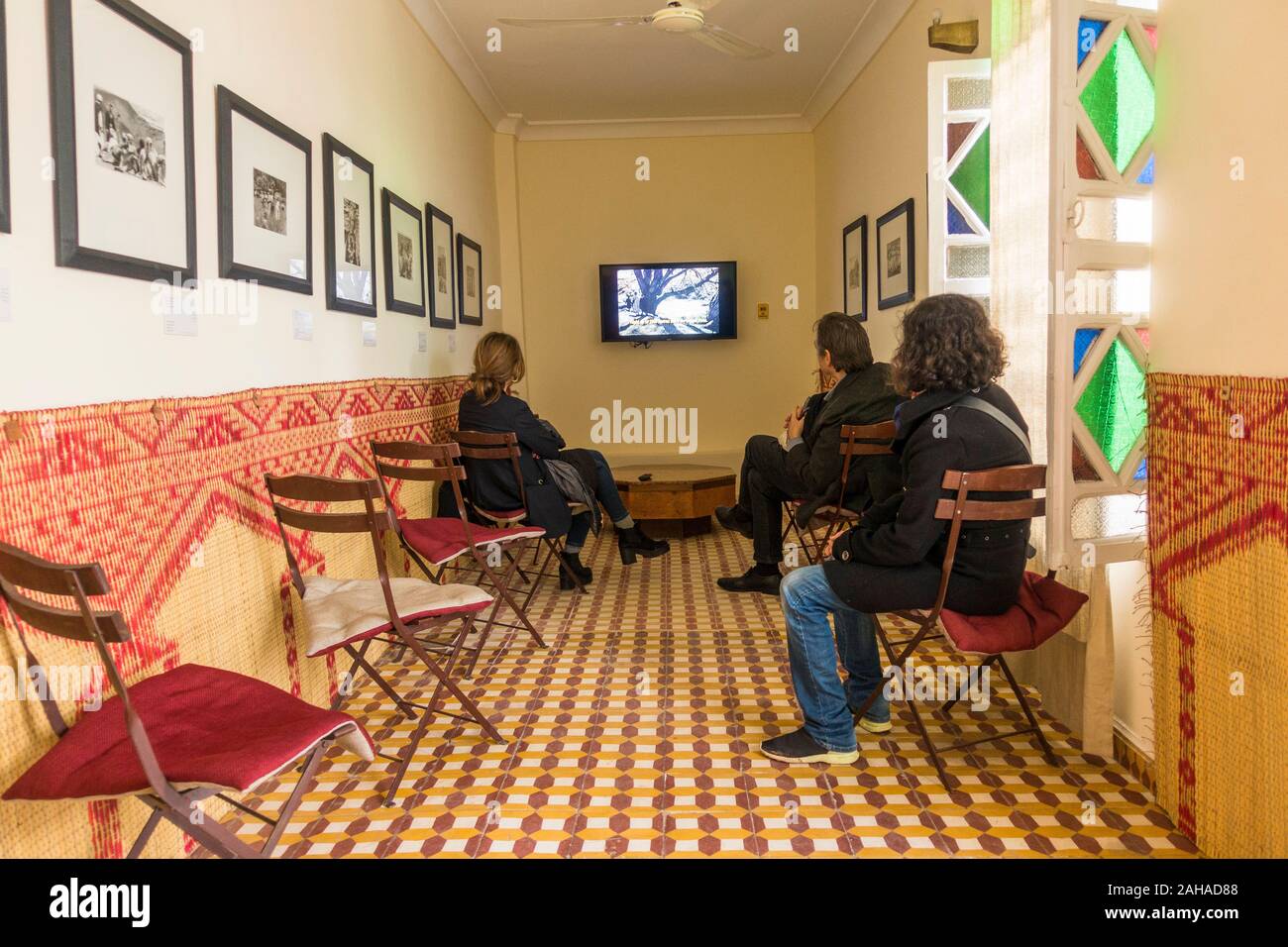Visitatori la visione di documentari in casa di fotografia della Maison de la Photographie di Marrakech, Marocco. Foto Stock