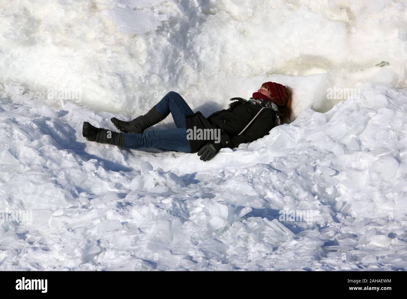 02.03.2018, Helsinki , Finlandia - donna sdraiata sulla neve a prendere il sole. 00S180302D244CAROEX.JPG [modello di rilascio: sì, la proprietà di rilascio: NO (c) caro immagine Foto Stock