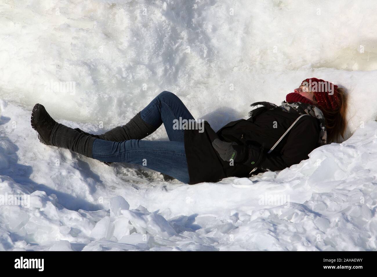 02.03.2018, Helsinki , Finlandia - donna giaceva nella neve e sole. 00S180302D042CAROEX.JPG [modello di rilascio: sì, la proprietà di rilascio: NO (c) caro ho Foto Stock