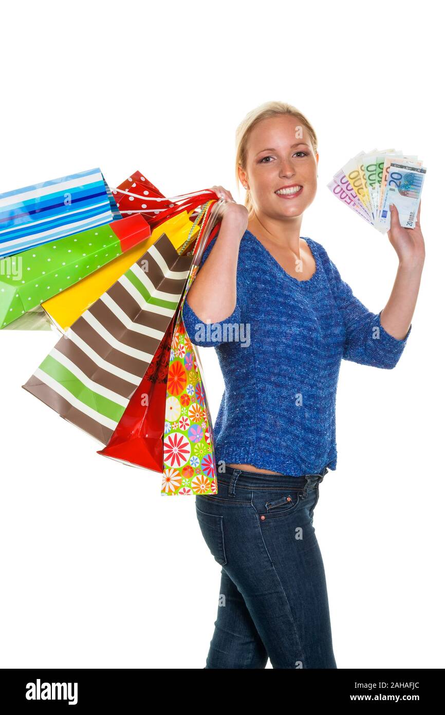 Eine junge Frau kommt mit vielen Einkaufstaschen vom Shopping zurück. In der ein mano Bündel Euro Geldscheine, signor: Sì Foto Stock