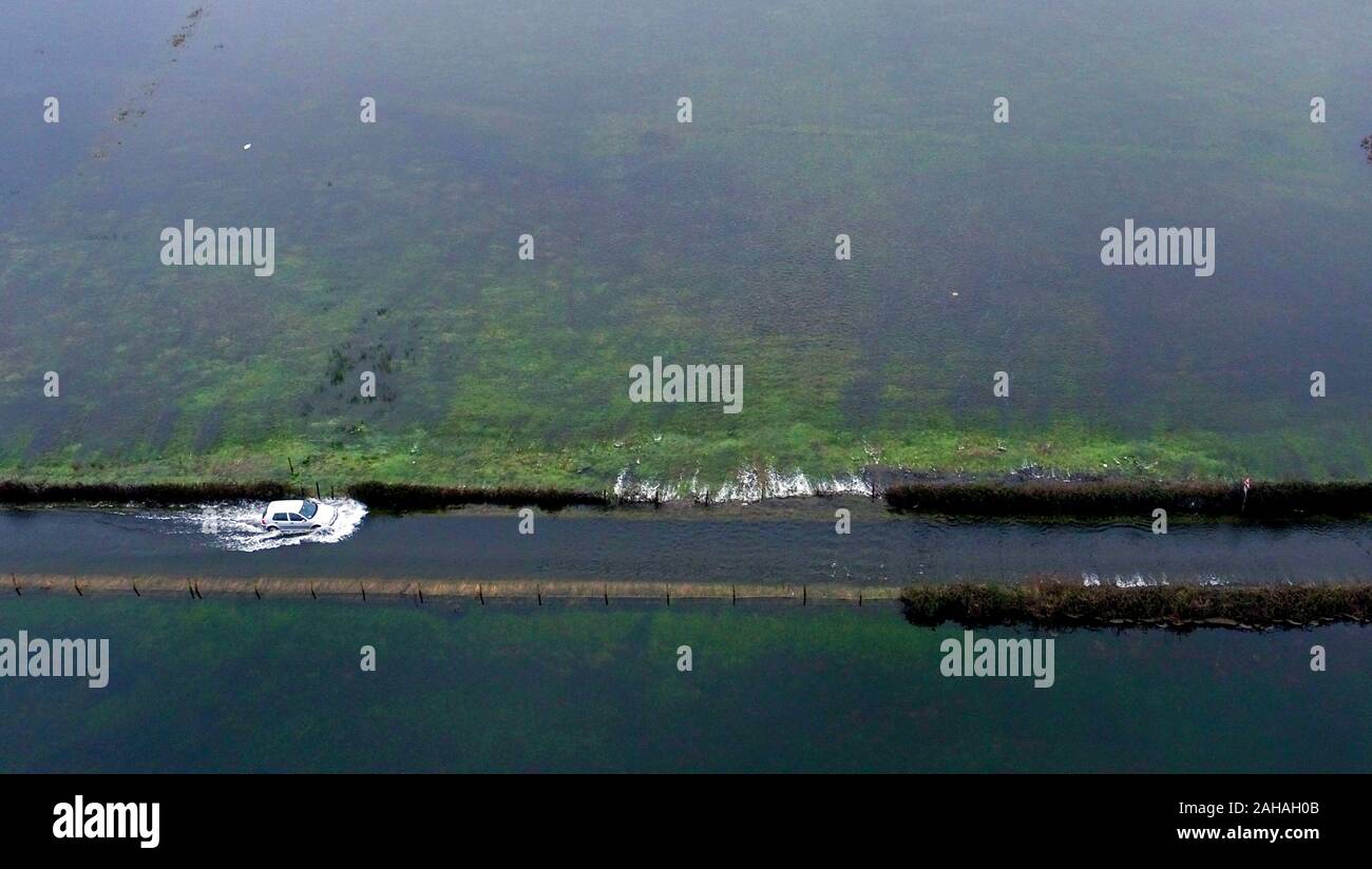 Una unità di auto attraverso inondazione vicino Harbridge, 2,5 miglia a nord di Ringwood in Hampshire, dopo il fiume Avon scoppiare le sue rive. Foto Stock