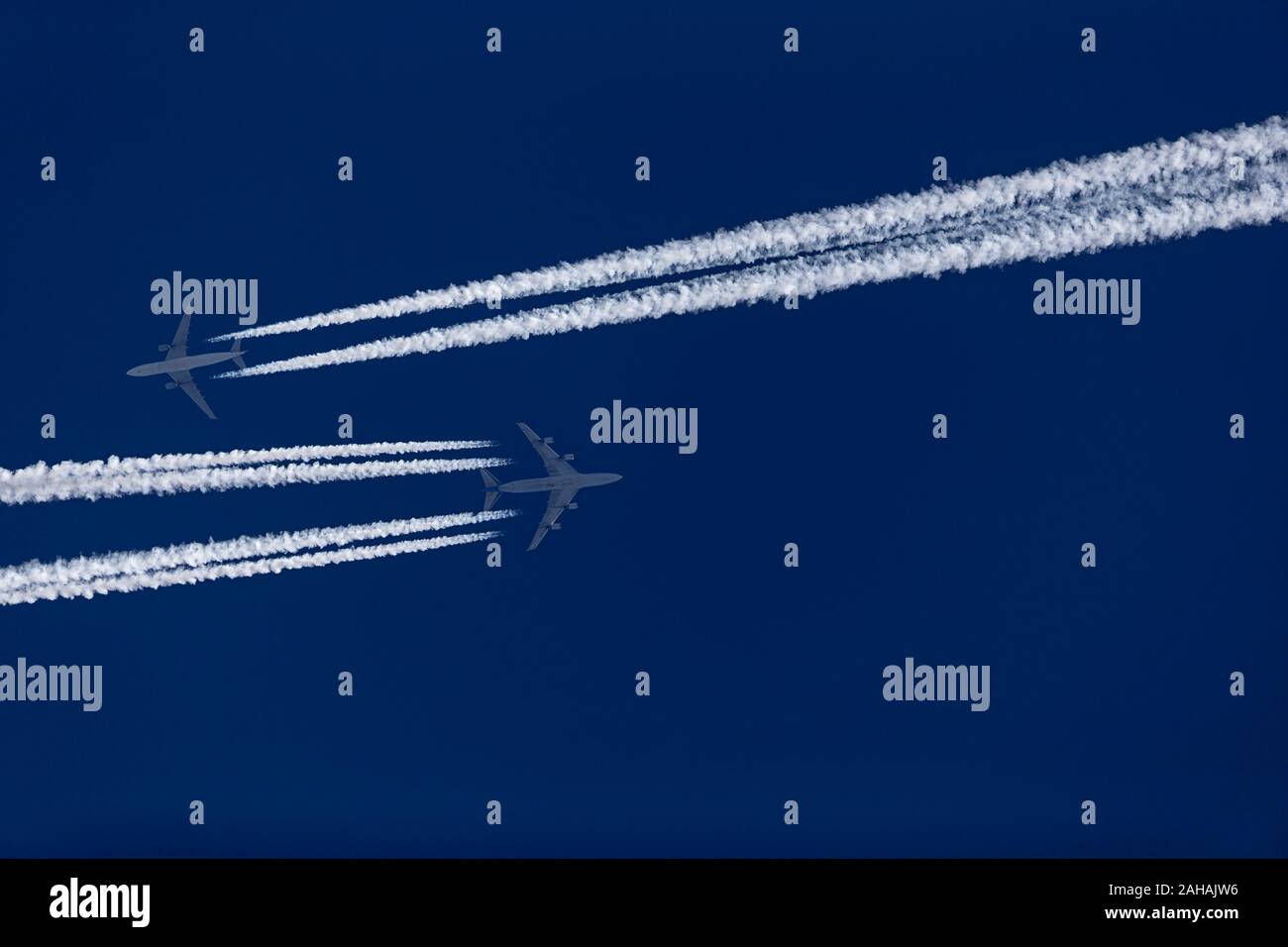 Due velivoli con contrails nel cielo blu Foto Stock