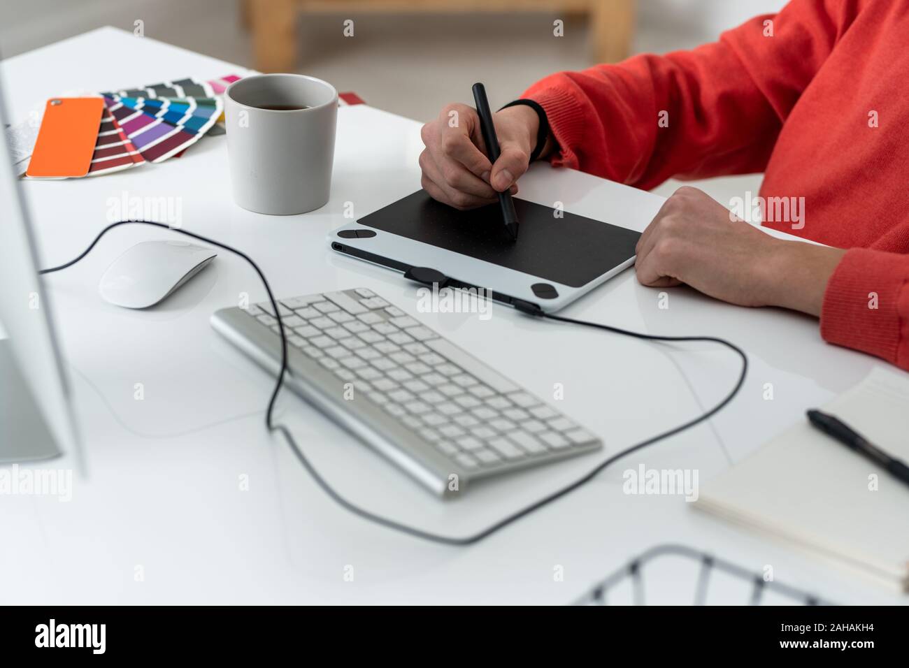 Le mani del giovane maschio freelancer con stilo ritocco foto in tavolette grafiche Foto Stock