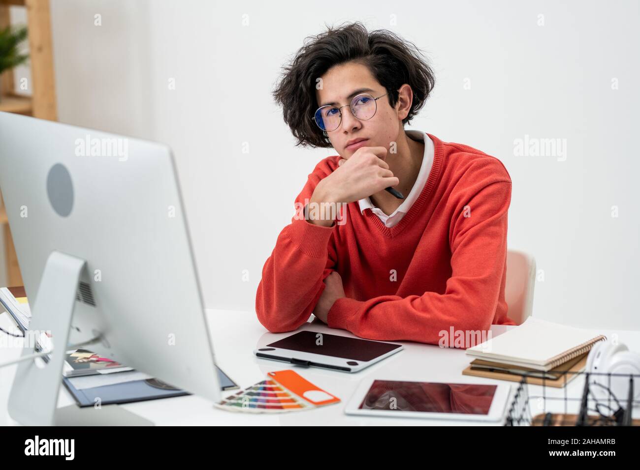 Malinconici freelancer in informale e occhiali a lavorare nella parte anteriore del computer Foto Stock