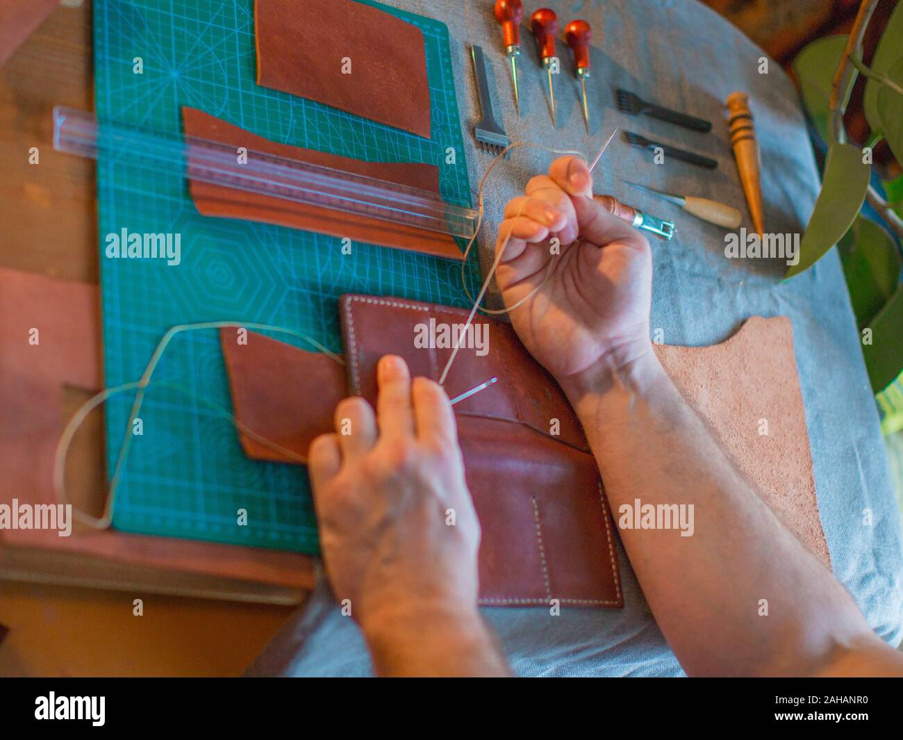 Vista ravvicinata di un artigiano mani. In pelle di cucitura. Chaft e concetto di fatti a mano. Foto Stock