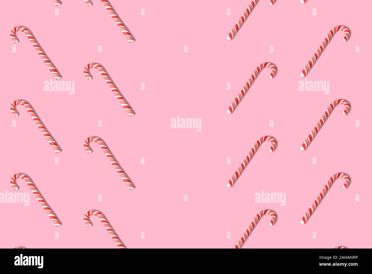 Candy canes pattern sul rosa pastello background creativo minima Natale o Capodanno concetto. Spazio per la copia. Foto Stock