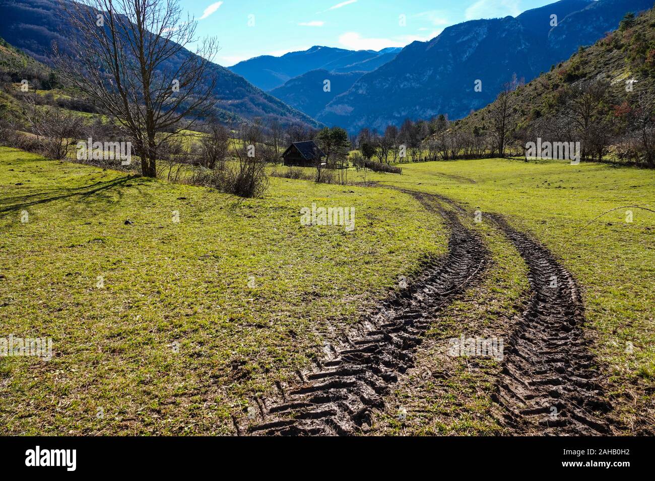 Terreni fangosi i cingoli del trattore nel campo, Ariège, Pirenei francesi, Francia Foto Stock