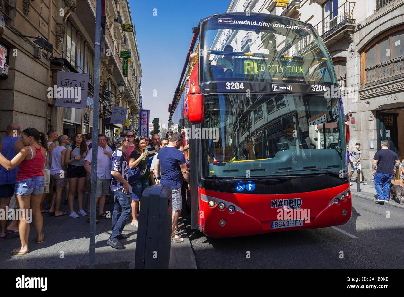 La gente a salire su una gita in autobus a una fermata di autobus di Madrid, Spagna Foto Stock