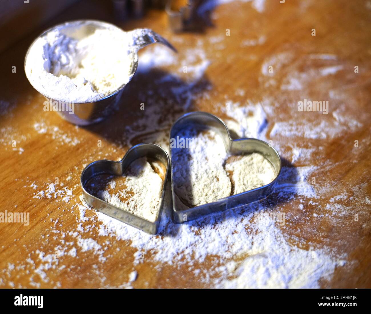 Due heartshaped coockiemolds in che cosa la farina su un tavolo woodcabin Foto Stock