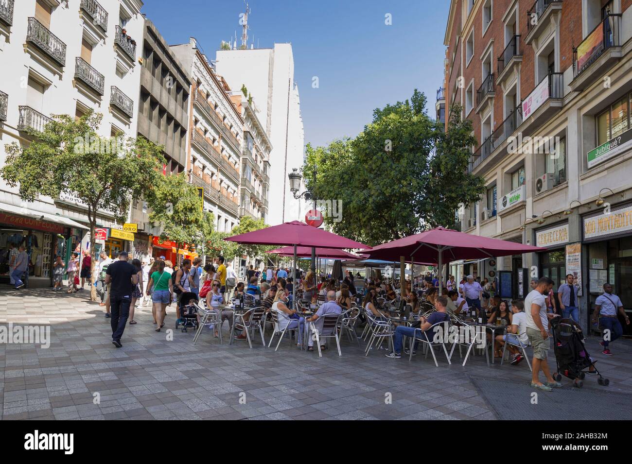 La gente seduta sotto grandi ombrelloni in un cafe' sul marciapiede di Madrid in Spagna Foto Stock
