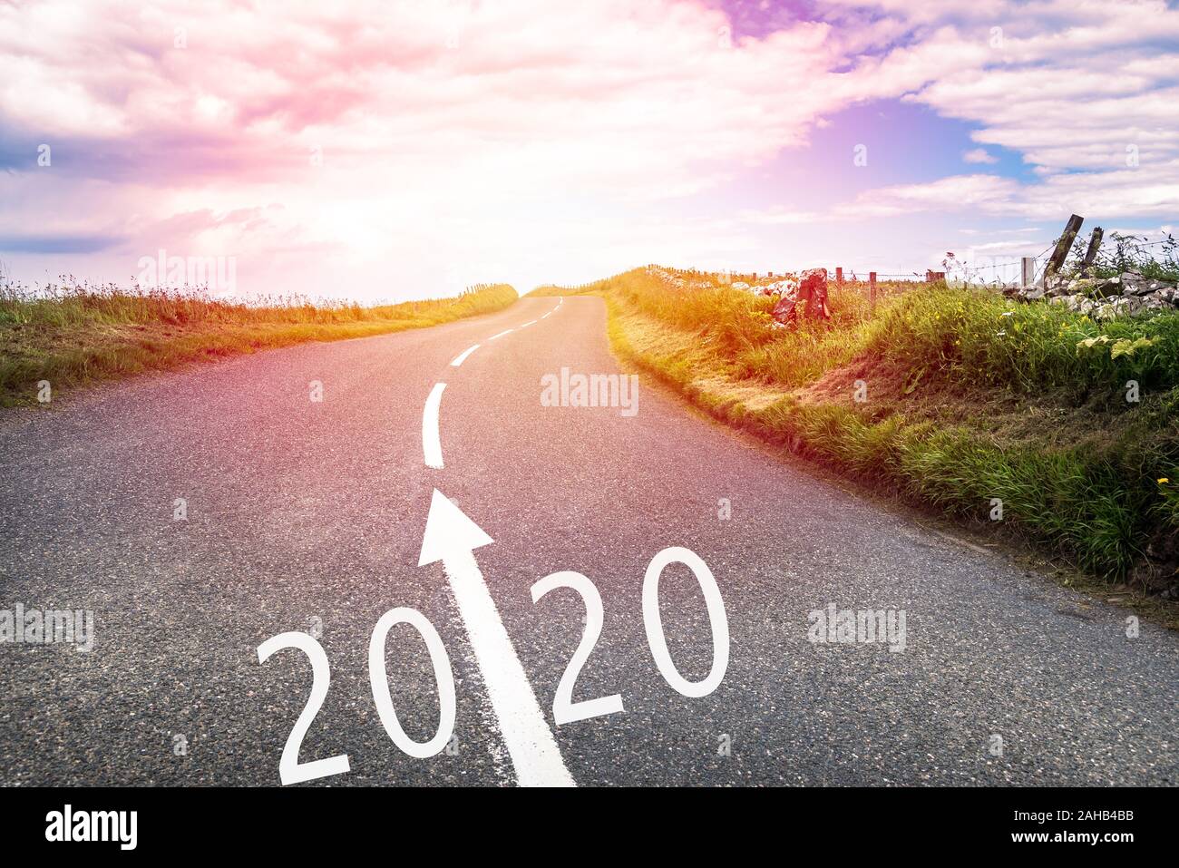 Nuovo anno 2020 in avanti. Paese concettuale road con 2020 e una freccia dipinta su asfalto. Foto Stock